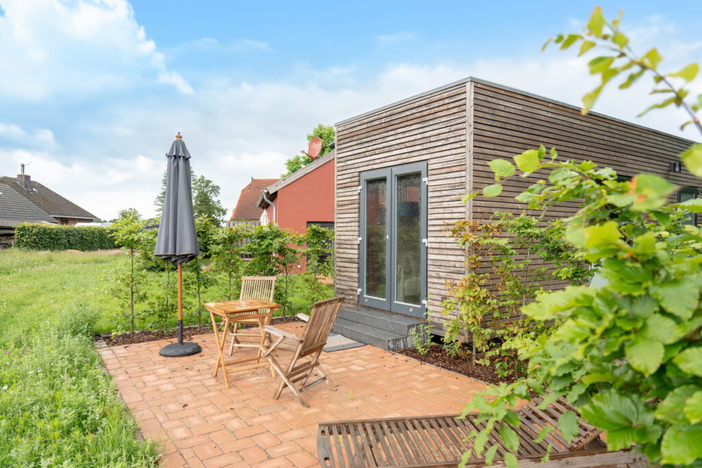 Ein Tiny House von NAWALO mit einer gepflasterten Terasse.