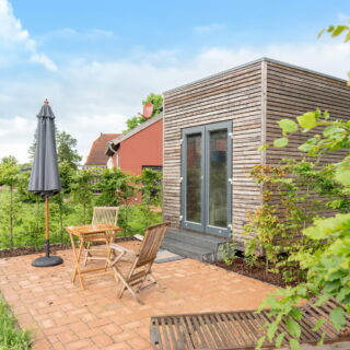 Ein Tiny House von NAWALO mit einer gepflasterten Terasse.